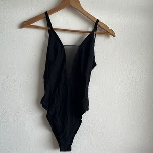 Black bodysuit with plunging neckline and open back.
